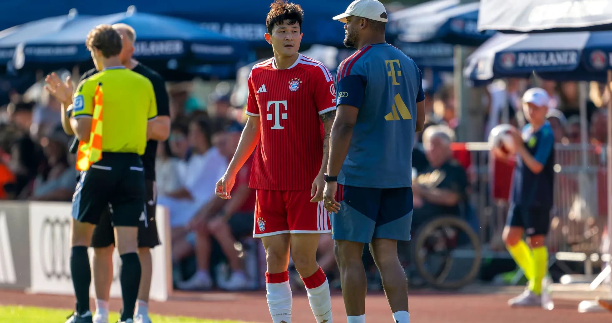 Bayern Munich player conversing with coach during match