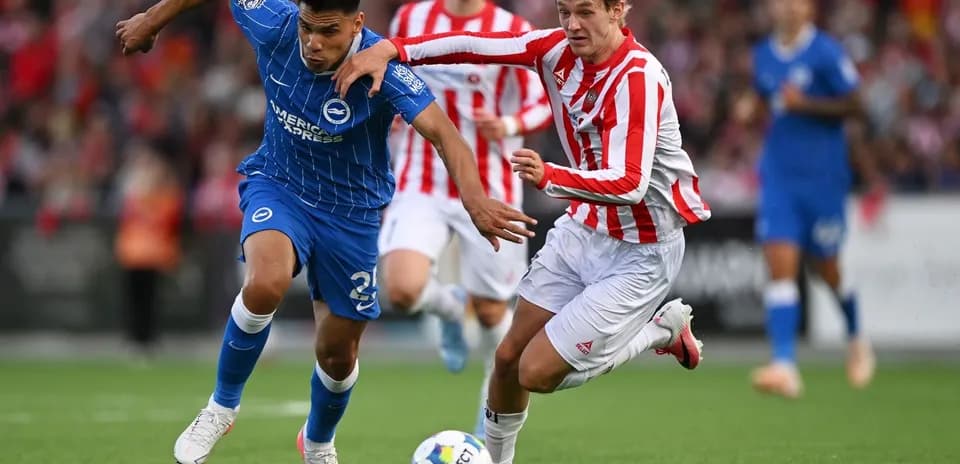 Player in blue and player in red competing for ball