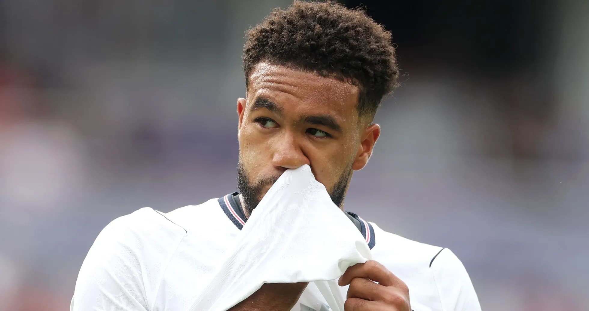 Player holding shirt to his face on the field