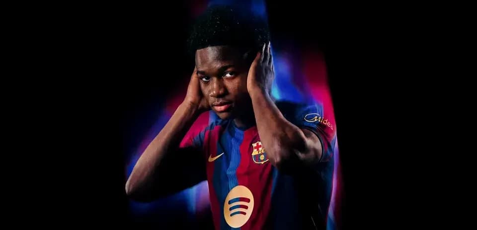 Player wearing Barcelona jersey posing with hands on ears