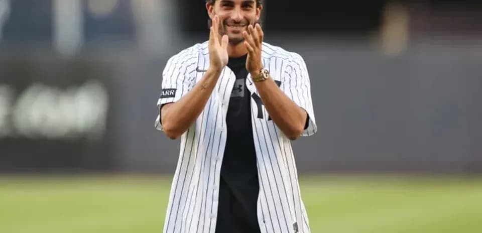 Man in Yankees jersey clapping on baseball field