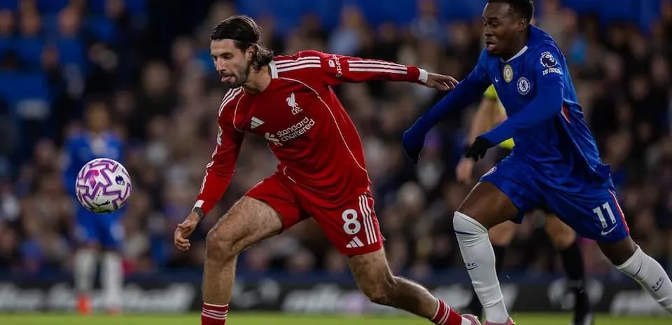 Liverpool player tackling Chelsea opponent during match