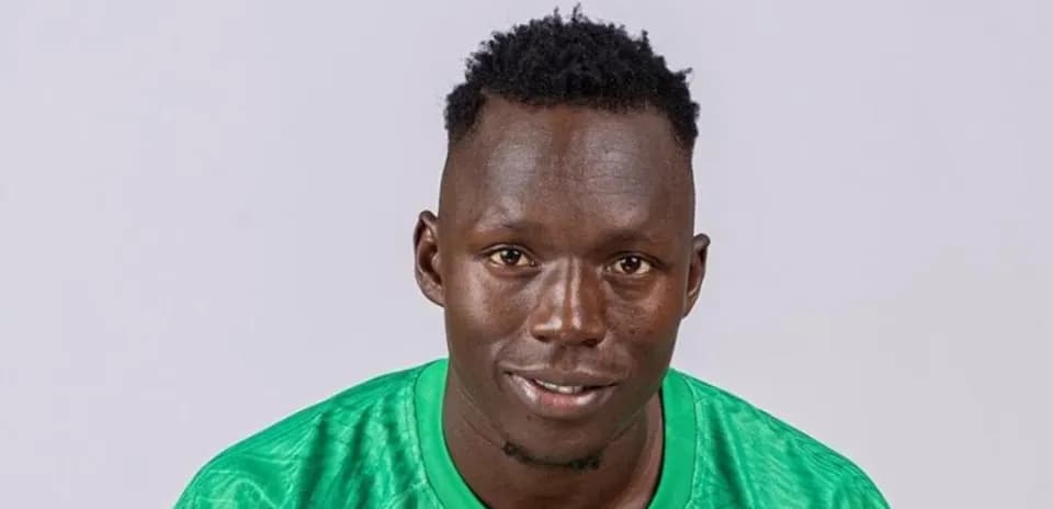 Goalkeeper in green jersey smiling for portrait