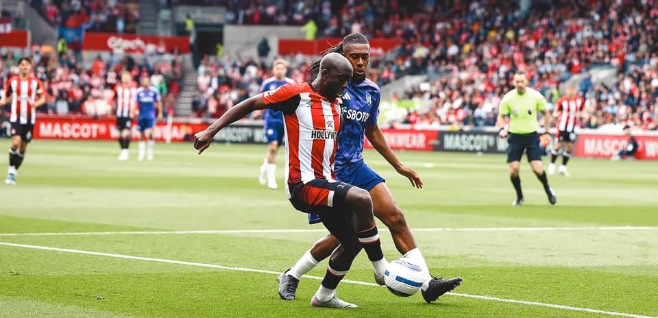 Brentford player competing for the ball against Fulham
