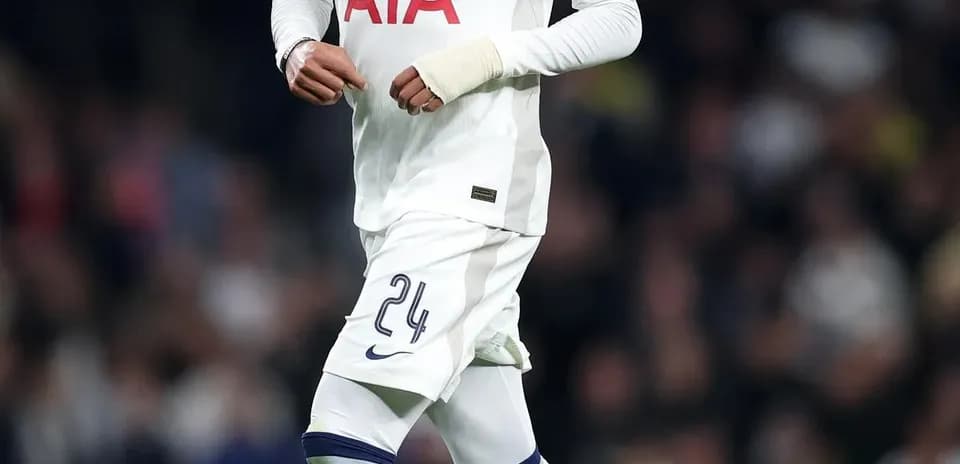 Player in Tottenham kit dribbling ball on pitch