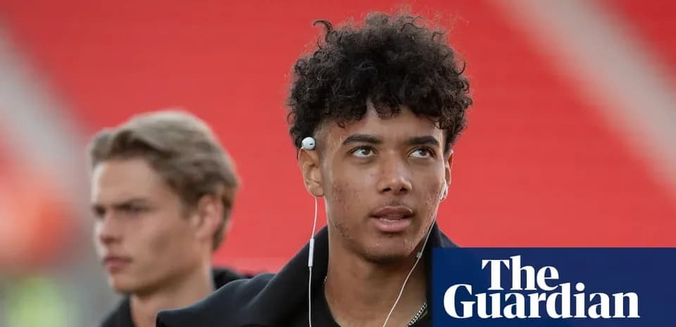 Young player wearing earphones in stadium hallway