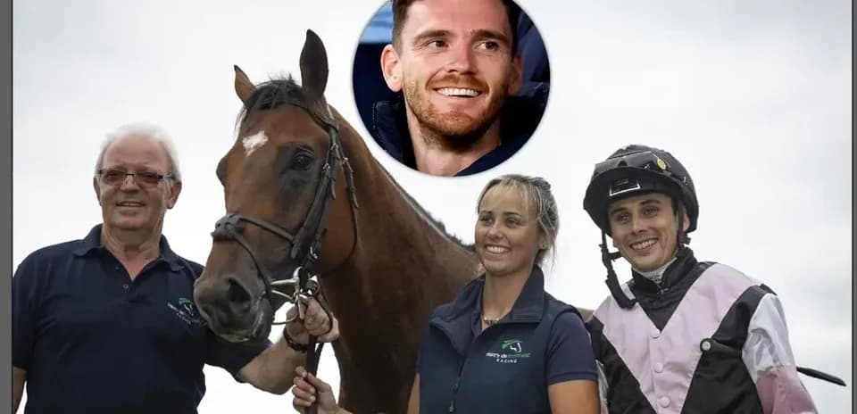 Team with horse posing for photo at racetrack