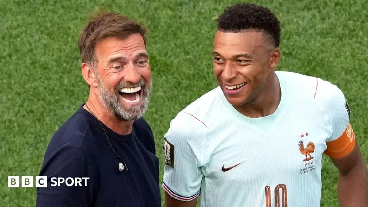 Two men smiling on the football pitch