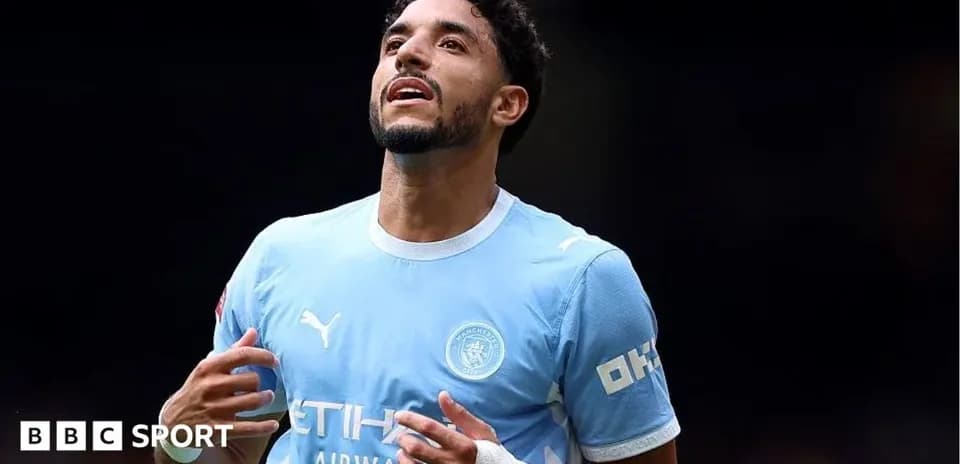 Player celebrating in Manchester City jersey on field
