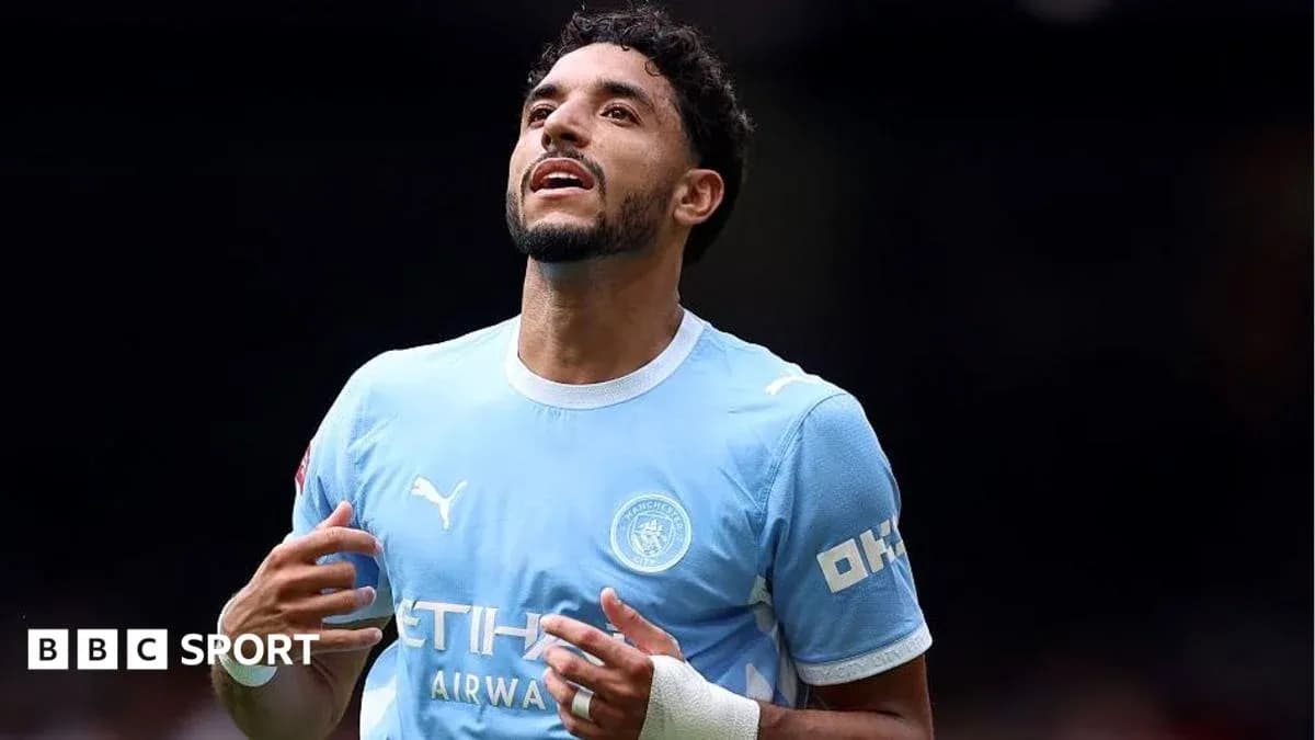 Player celebrating in Manchester City jersey on field