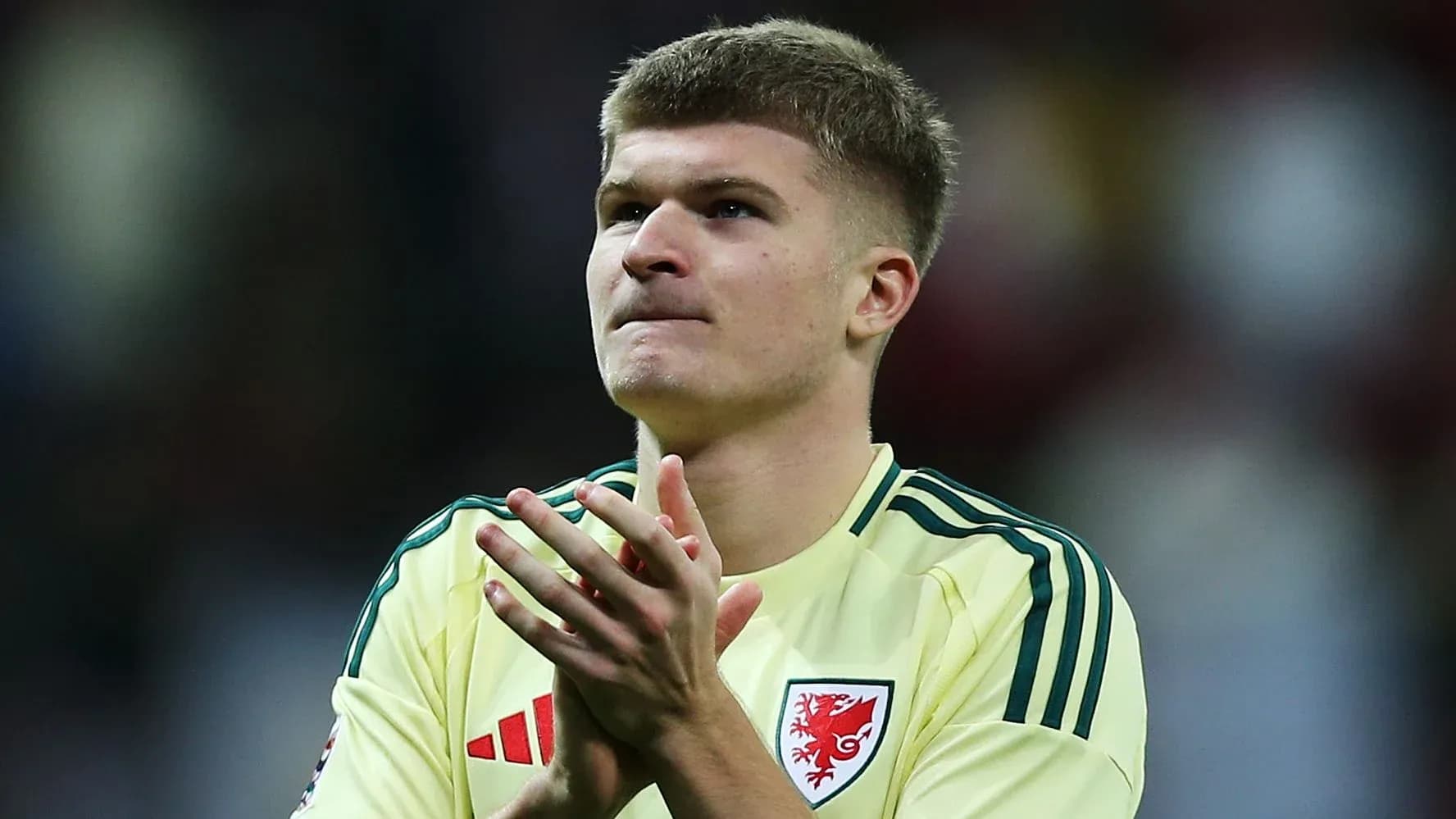 Player in yellow jersey applauding after match