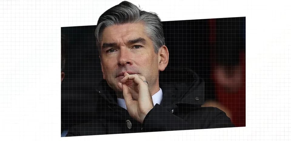 Man observing match from the stands in a coat