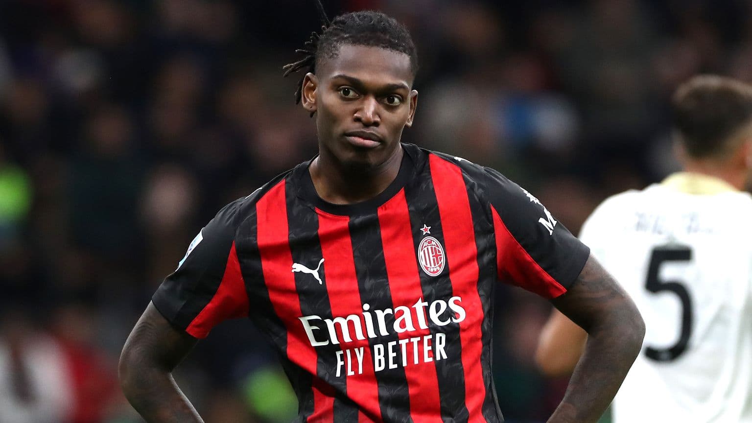 AC Milan player in red and black jersey on field