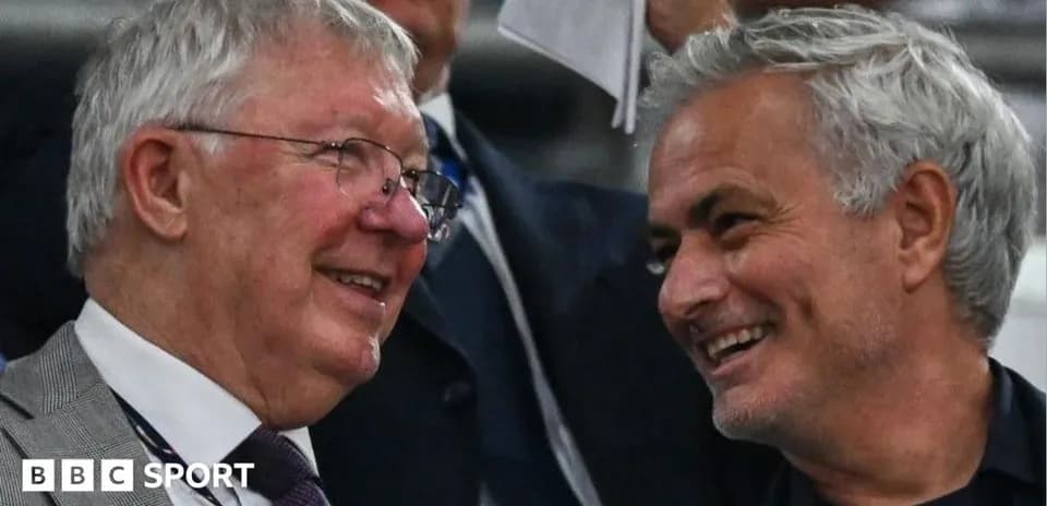 Two men smiling and conversing in a stadium