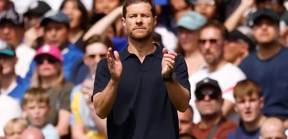 Coach applauding during a match with fans in background