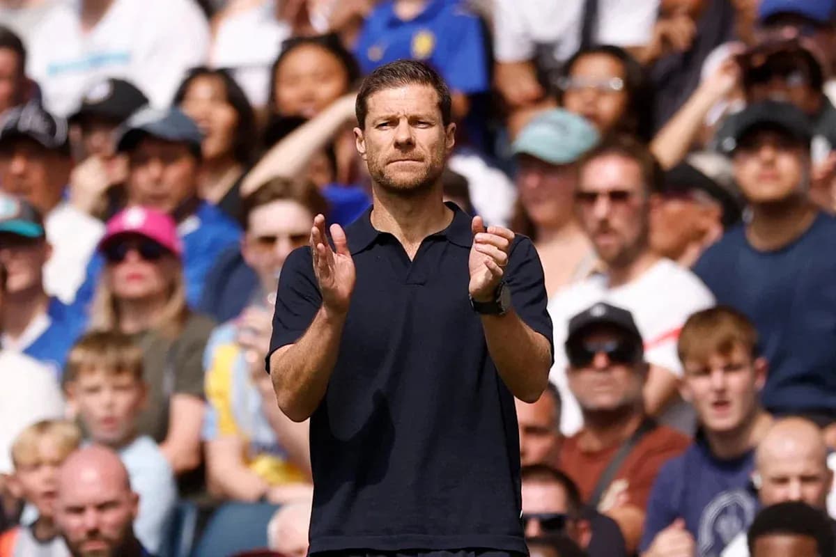 Coach applauding during a match with fans in background