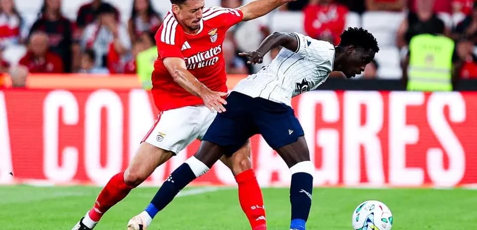 Benfica player challenging Aarhus opponent for the ball