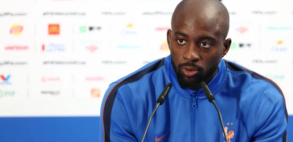 Player speaking at a press conference podium