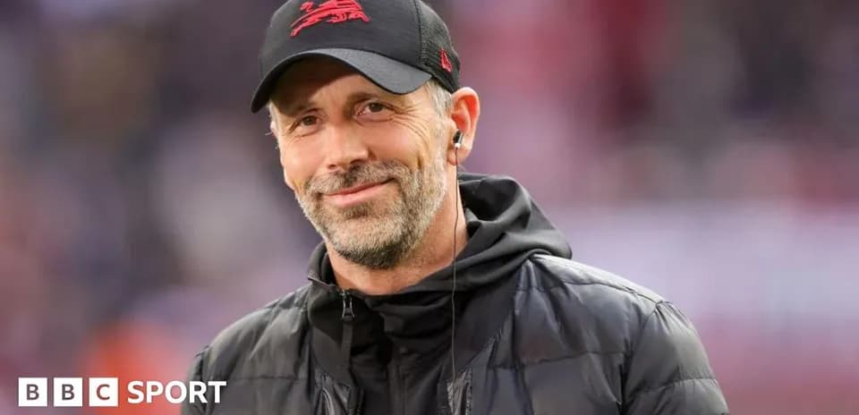 Coach smiling on the sidelines during a match