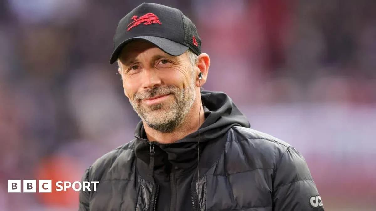 Coach smiling on the sidelines during a match