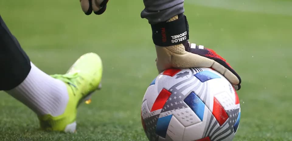 Goalkeeper placing ball on grass before kick