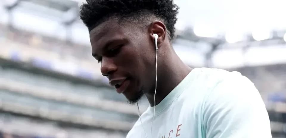 Player wearing earbuds, looking down before match