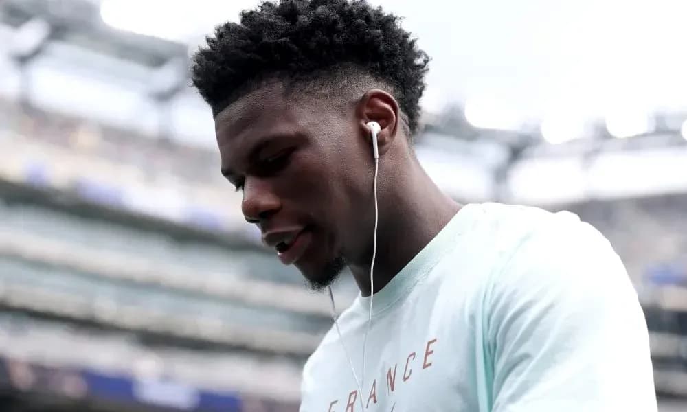 Player wearing earbuds, looking down before match