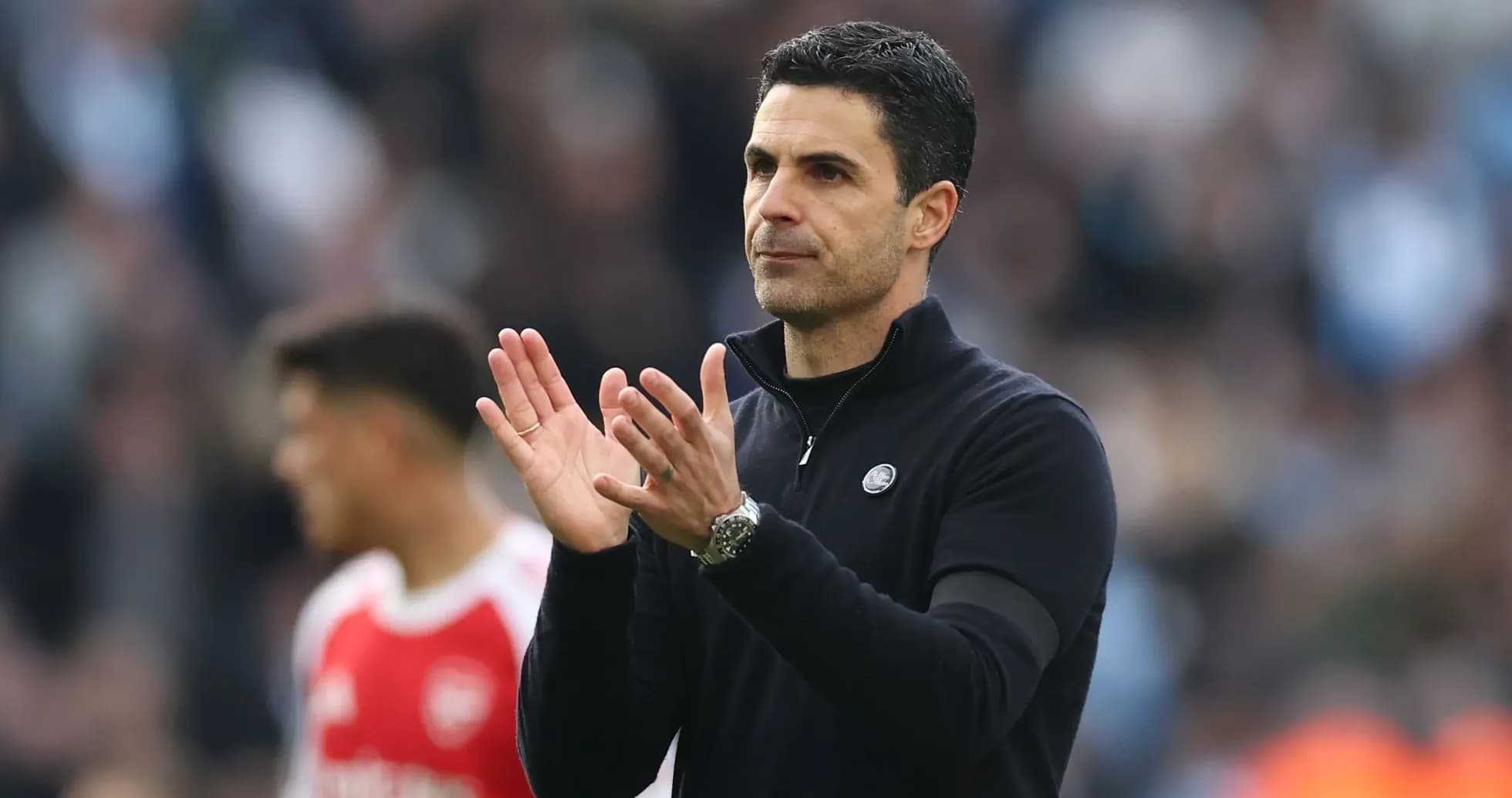 Manager clapping during match with players in background