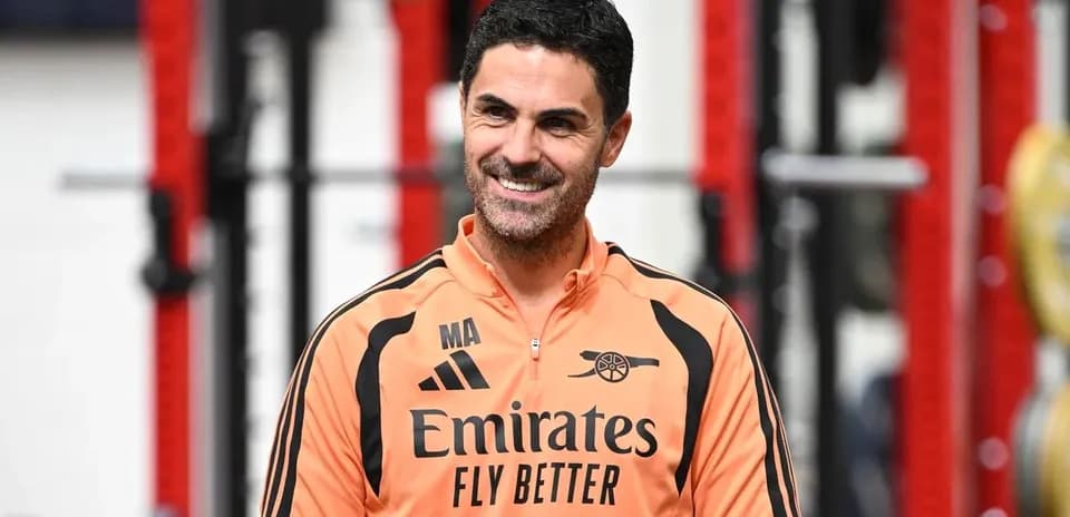 Arsenal manager in training facility smiling