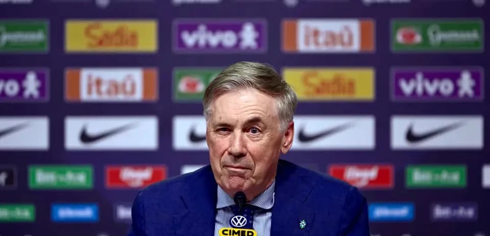 Coach speaking at press conference with sponsor banners