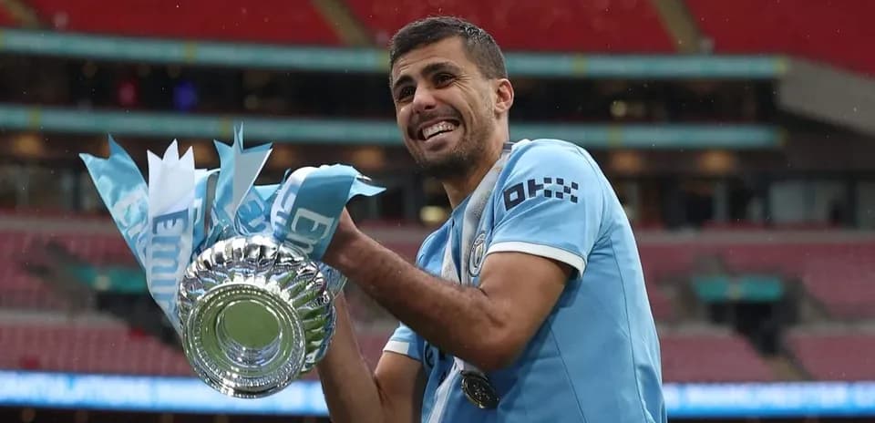 Player celebrating with trophy at Wembley Stadium
