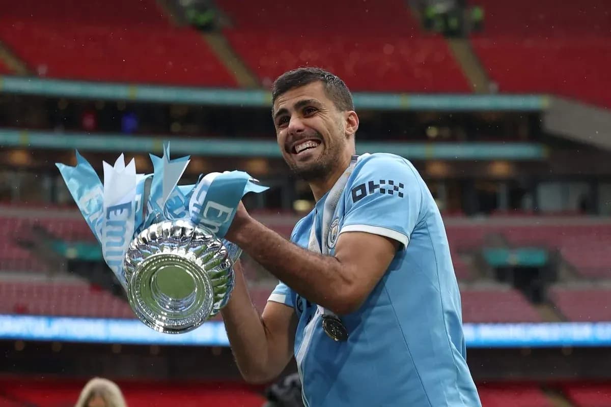Player celebrating with trophy at Wembley Stadium