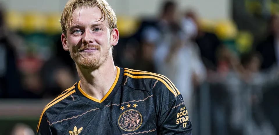 Football player smiling in Ajax jersey after match