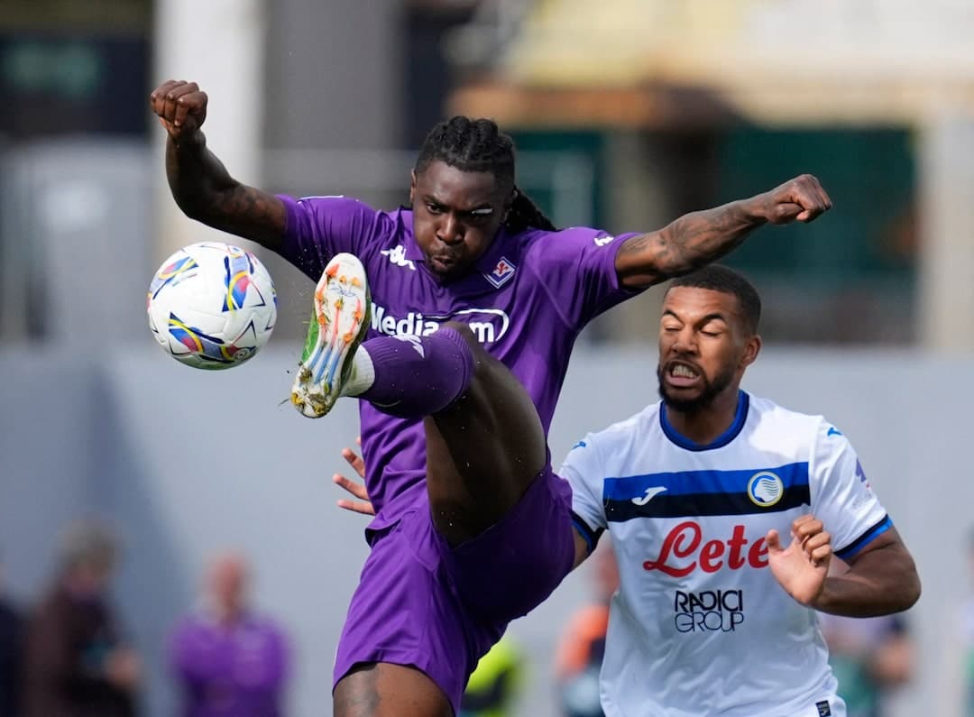 Fiorentina player kicking ball against Atalanta opponent
