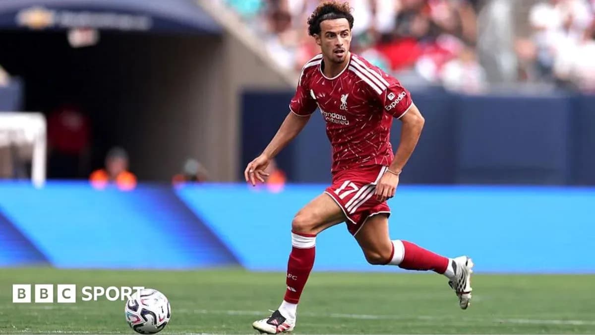 Player in red kit dribbling the ball during match