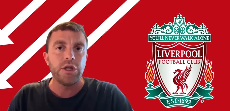 Person speaking in front of Liverpool FC logo