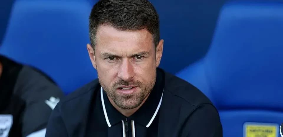 Manager seated on bench during match preparation