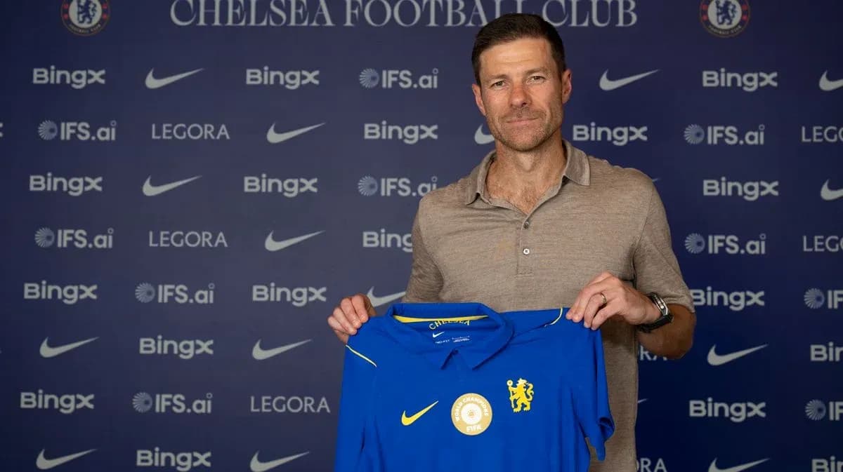 New coach holding Chelsea FC jersey at announcement