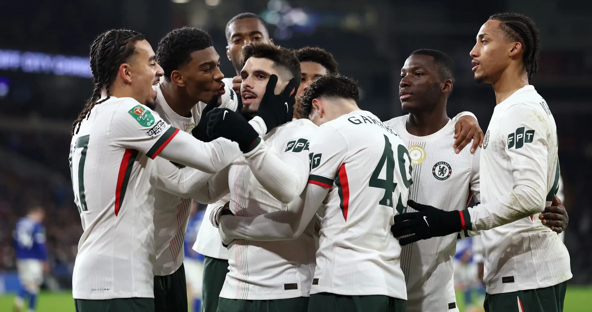 Chelsea players celebrating a goal together on field