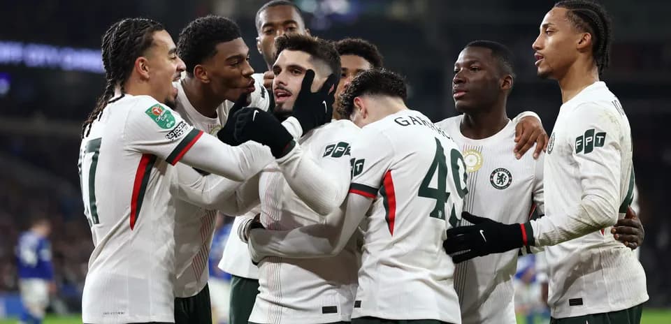 Chelsea players celebrating a goal together on field