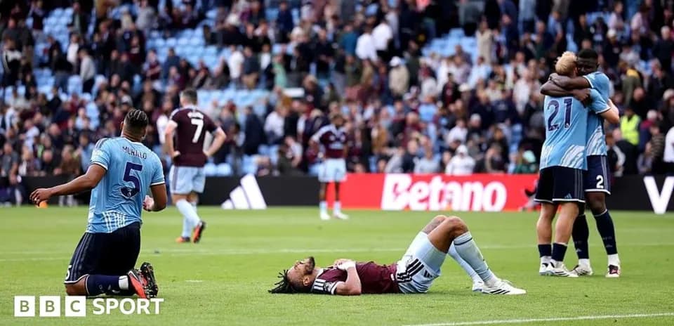 Players reacting after match, one on the ground