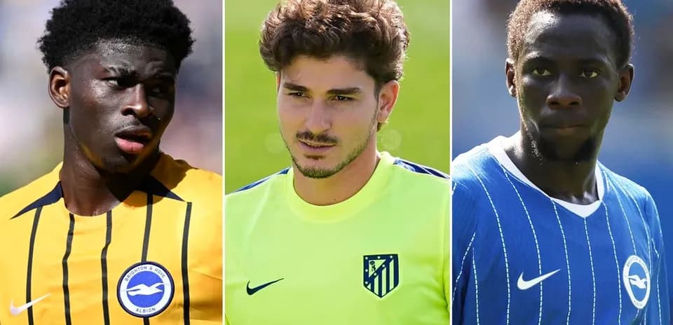Three soccer players in team jerseys posing for photo