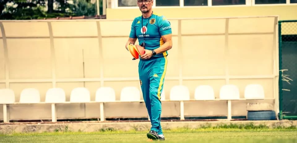 Coach walking on field holding training equipment
