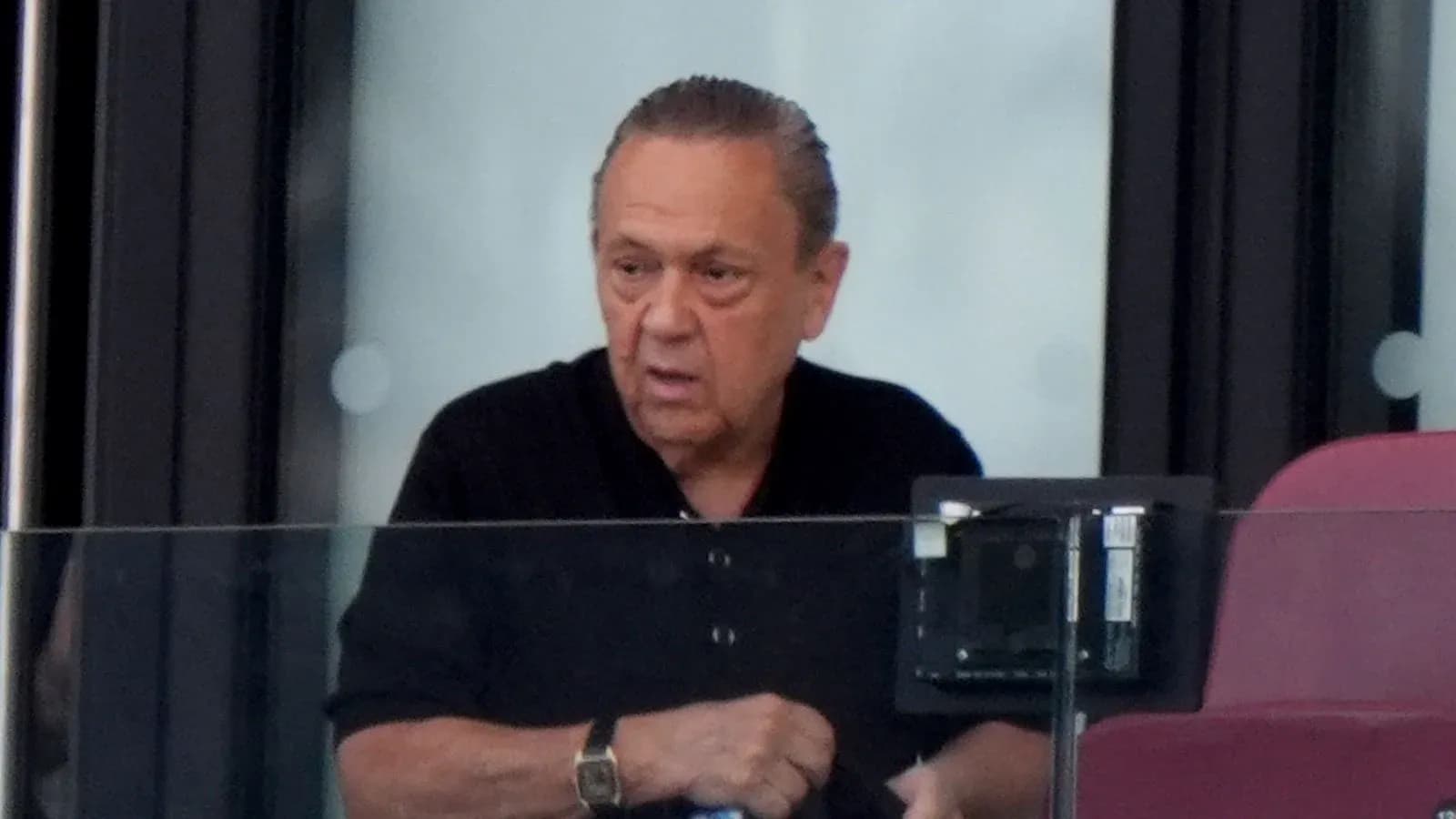 Man observing from a box at a stadium