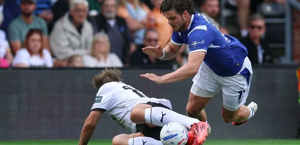 Player tackling opponent on the pitch during match