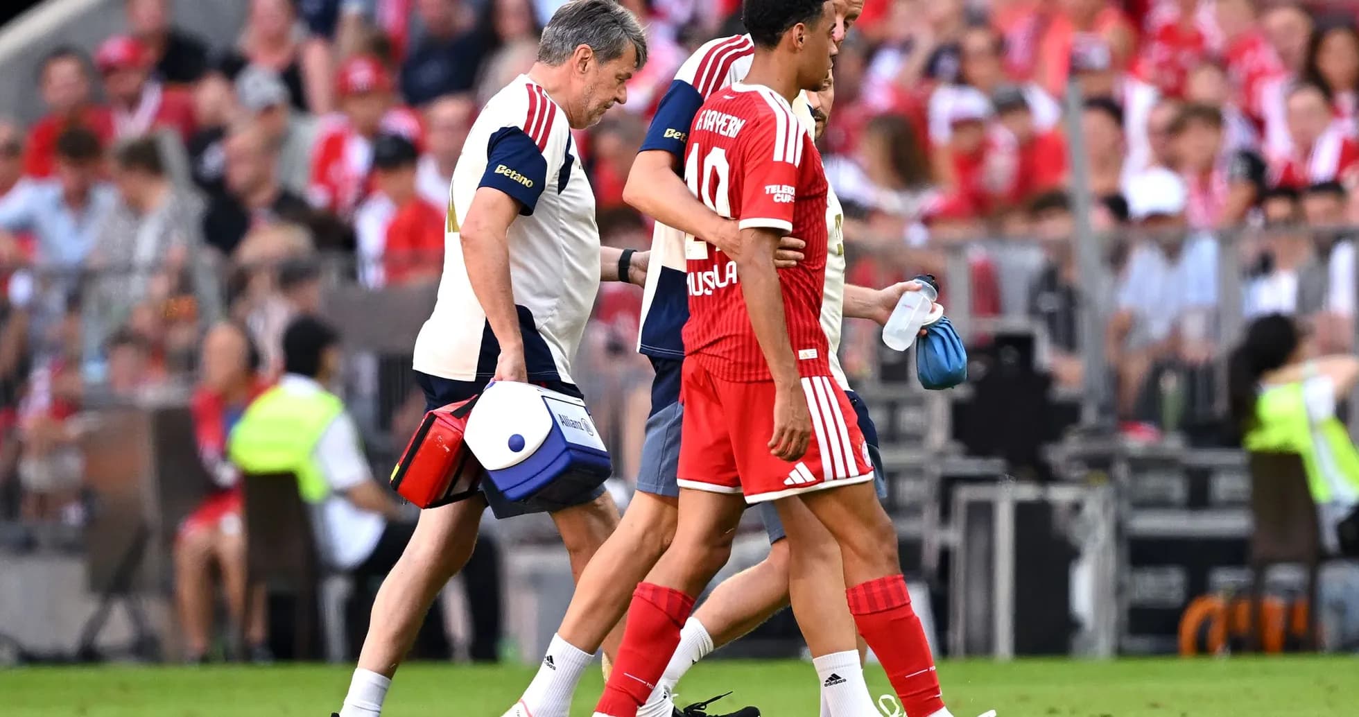 Player being assisted off the field by staff