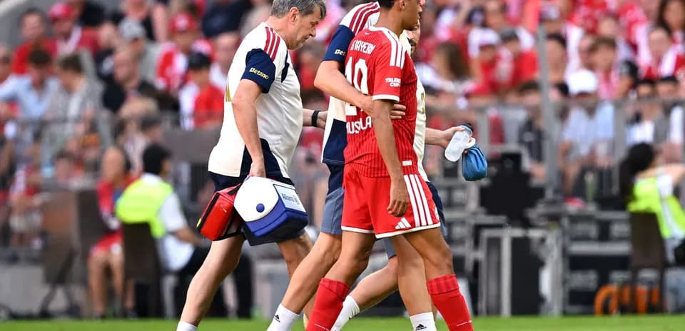 Player being assisted off the field by staff