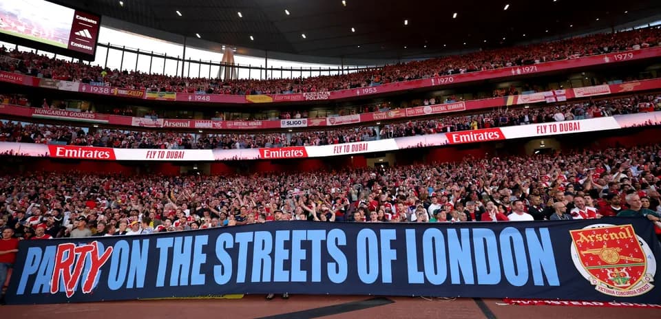 Arsenal fans holding banner at Emirates Stadium