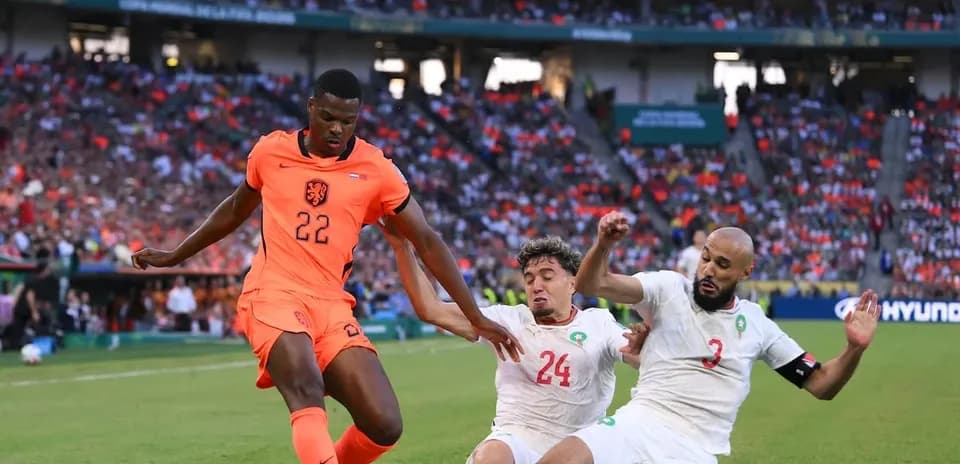 Player 22 of Netherlands dribbling past two defenders