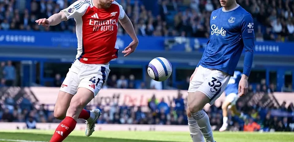 Arsenal player kicking ball near Everton defender